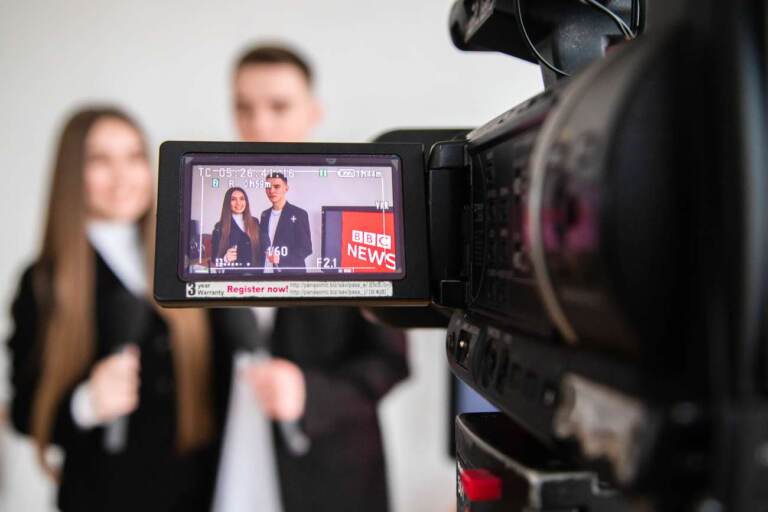 В камері відображається двоє студентів-журналістів з мікрофонами