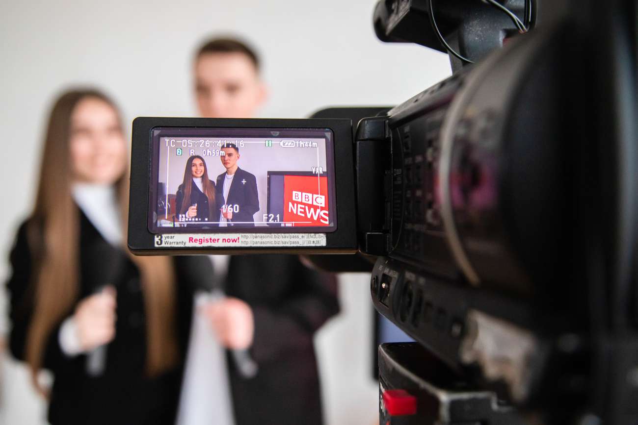 В камері відображається двоє студентів-журналістів з мікрофонами